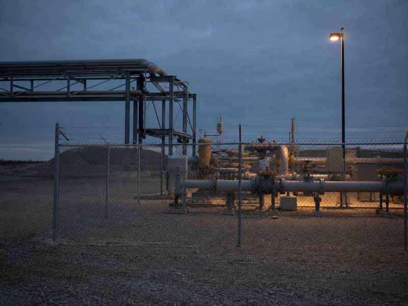 Estación de medición de gas al anochecer, con la luz de trabajo encendida